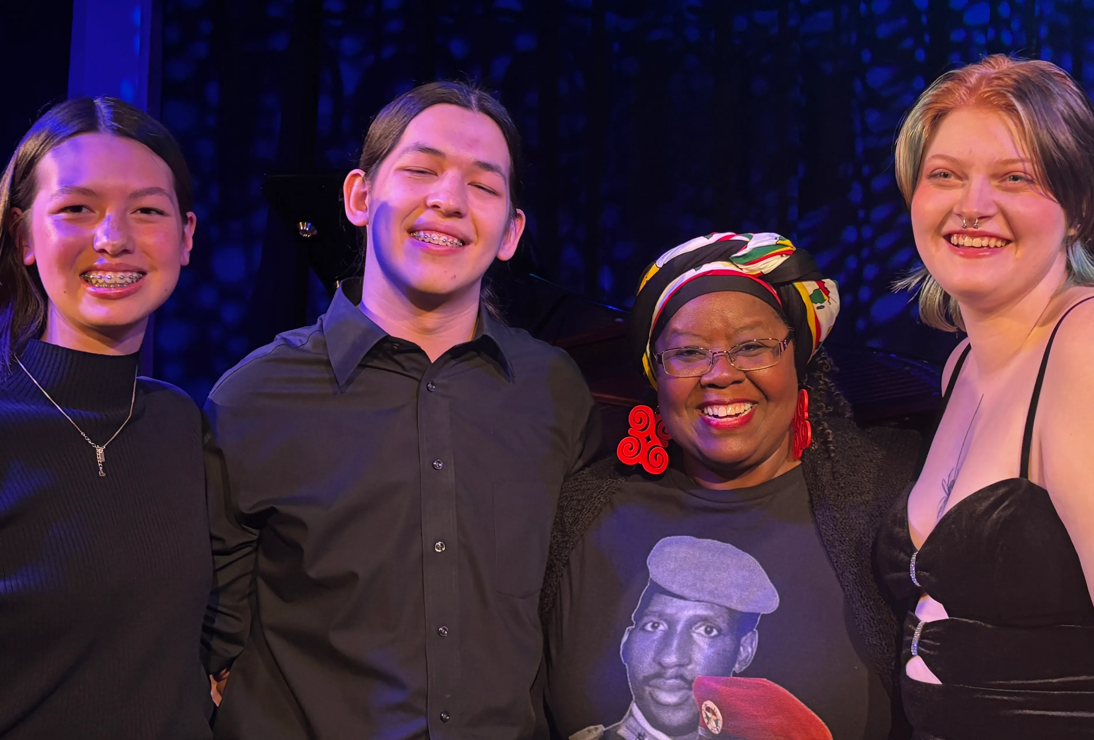 Four Vocal Jazz students smile together for a group photo.